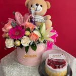 DM18 - Caja decorativa con rosas, lirios, gerberas, piba de jp, chocolates, peluche pequeño y torta pequeña.