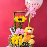 DM9 - Caja decorativa con rosas, claveles, girasol, chocolatina y peluche pequeño.
