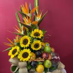 H40 - Arreglo floral con girasoles, aves del paraíso y frutas.