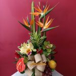 H38 - Arreglo floral con flores variadas y variedad de frutas.