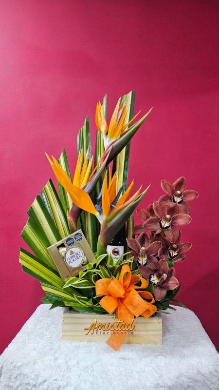 H22 - Arreglo con cymbidium, aves de paraíso, chocolates y vino.
