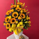 M18 - Florero con lirios, rosas, girasoles y chocolates.