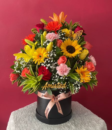 M8 - Caja decorativa con flores variadas y pin mariposa.