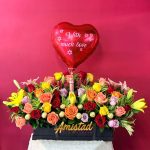 AA25 - Caja decorativa con rosas, lirios, chocolates, licor y globo personalizado.